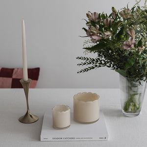 Telysholdere i kremfarge i forskjellige størrelser, dekorert med blomster og bordpynt, gir stil til interiøret.