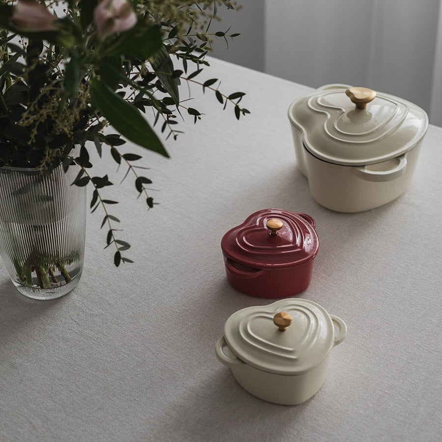 Seasons Love Collection Støpejernsform Hjerte Krem 10cm 0,3L sammen med andre formes på et bord, med fokus på deres elegante design.