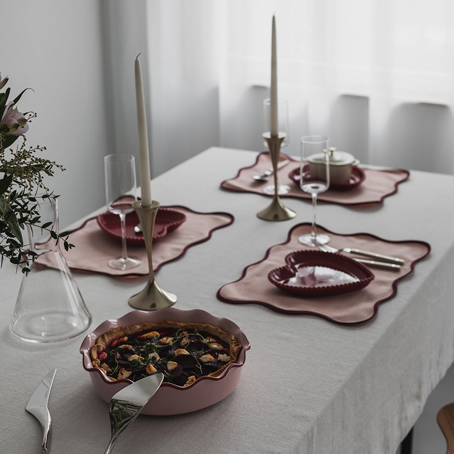 Season Love Collection ildfast form Rund 28cm 2,4L Rosa på et borddekk med stearinlys og dekorative elementer.