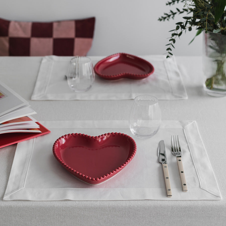 Seasons love Collection Tallerken Hjerte Bringebær Rød 20cm - Hjerteformet tallerken i bruk på elegant dekket bord med glass og bestikk.