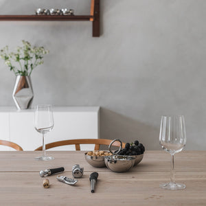 Stilren borddekking med Løve vinsett og glass, samt serveringsskåler med snacks. Perfekt for en elegant vinsmaking.