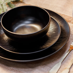 Vakkert oppsatt Mikasa Middagsservise Jardin Midnight 12 Deler Sort med ulike tallerkener og skåler plassert på et naturlig stoff.