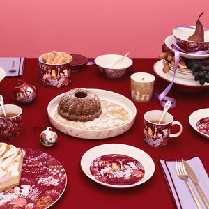 Festlig oppsett med Mummi bolle fra Moomin Arabia, inkludert flere serveringsfat og kopper, perfekt for julefeiring.