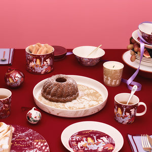 Moomin Arabia paiform satt i en festlig samling av servise og bakverk, perfekt for høytider og sammenkomster.