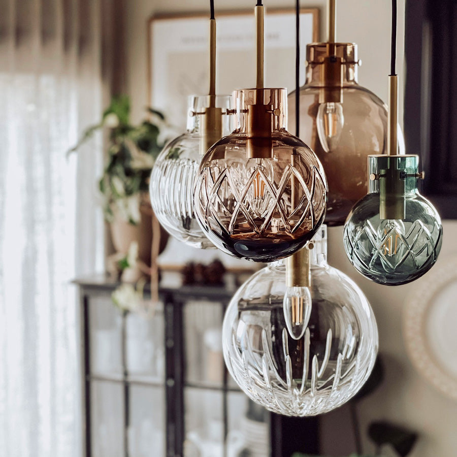 Hadeland Glassverk krystallkule taklampe hengende over et bord, detaljerte krystaller gir et sofistikert uttrykk med naturlig belysning.