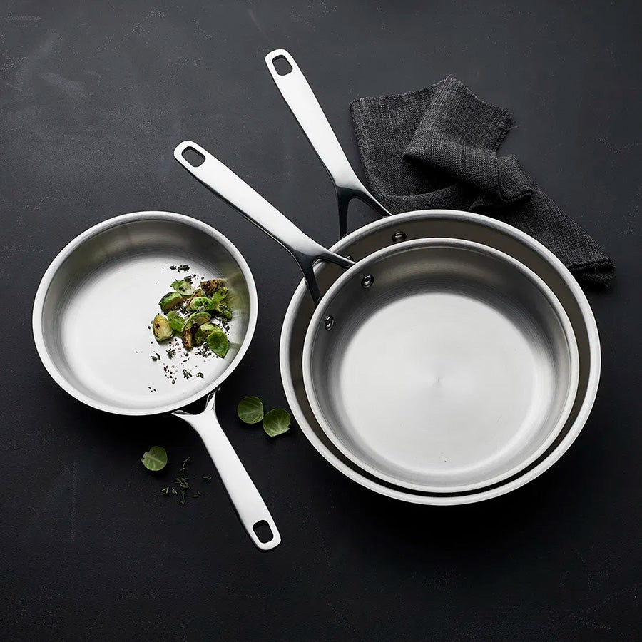 Tre Morsø stekepanner i rustfritt stål med grønnsaker, ideelle for allsidig matlaging.