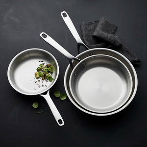 Tre Morsø stekepanner i rustfritt stål med grønnsaker, ideelle for allsidig matlaging.