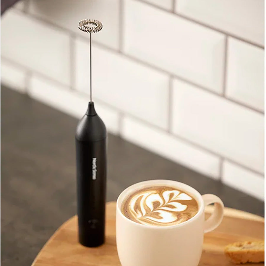 Nordic Sense svart melkeskummer og cappuccino på et kjøkkenbrett