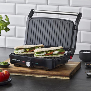 Nordic Sense Paninigrill i bruk med to fyllte paninier, presentert på et skjærebrett, inspirerende muligheter for middag og frokost.