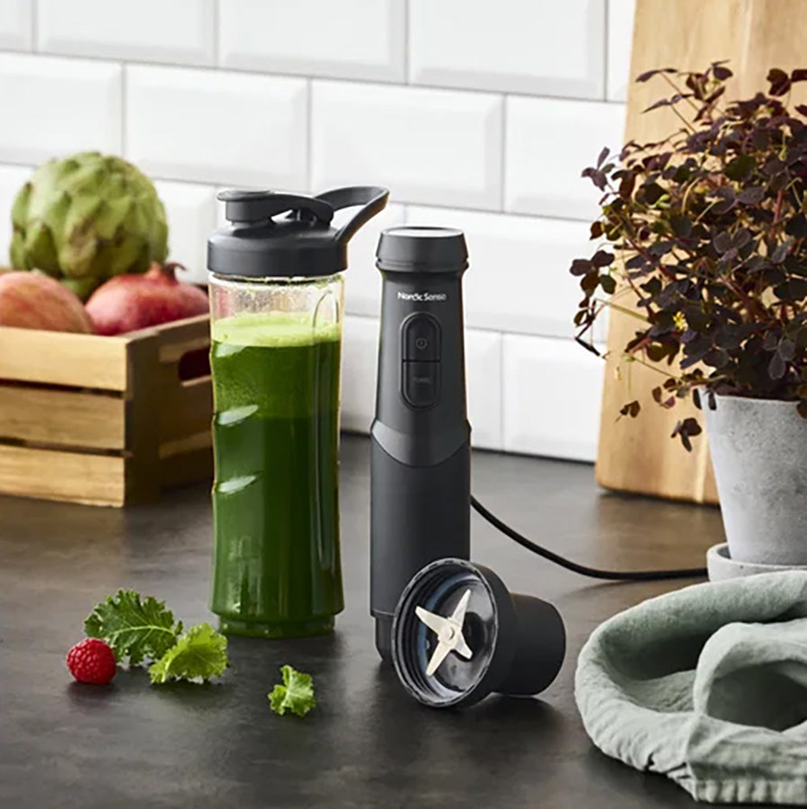 Nordic Sense stavmikser med smoothieflaske og grønnsaksblanding på kjøkkenbenken, det perfekte hjelpemiddelet for sunn matlaging.