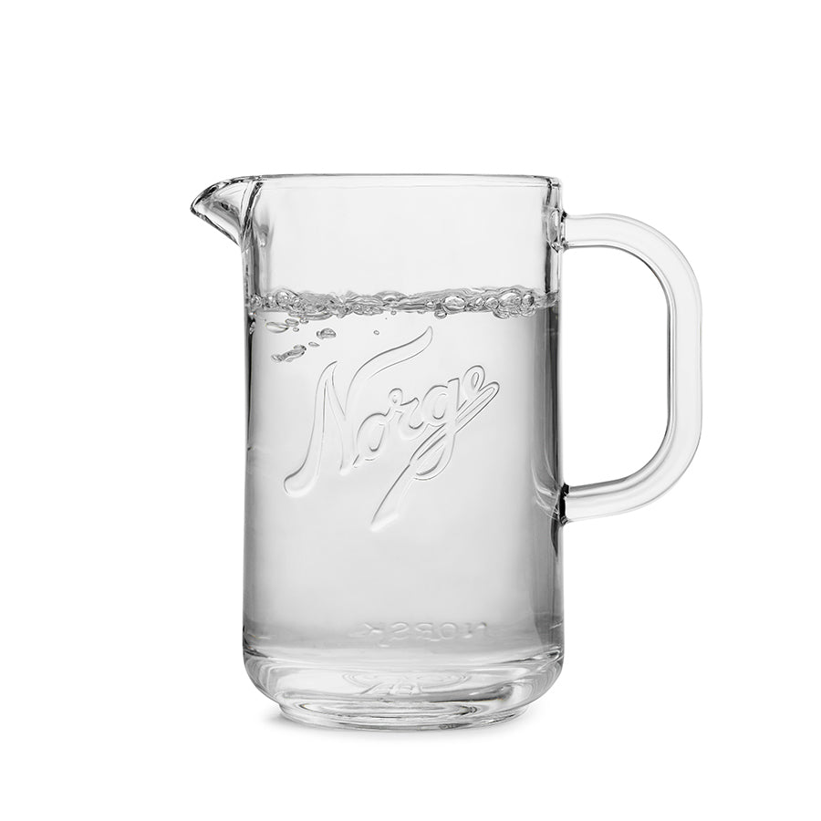 Norgesglasset glassmugge 1,2L fylt med klart vann, praktisk for hverdagsbruk.