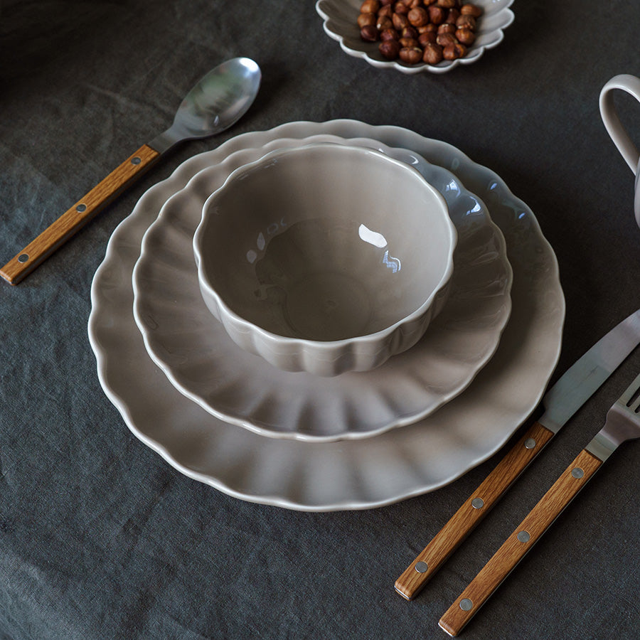 Stilren grå Lilly bolle, del av et elegant bordoppsett med tallerkener og bestikk, perfekt for servering av yoghurt og snacks.