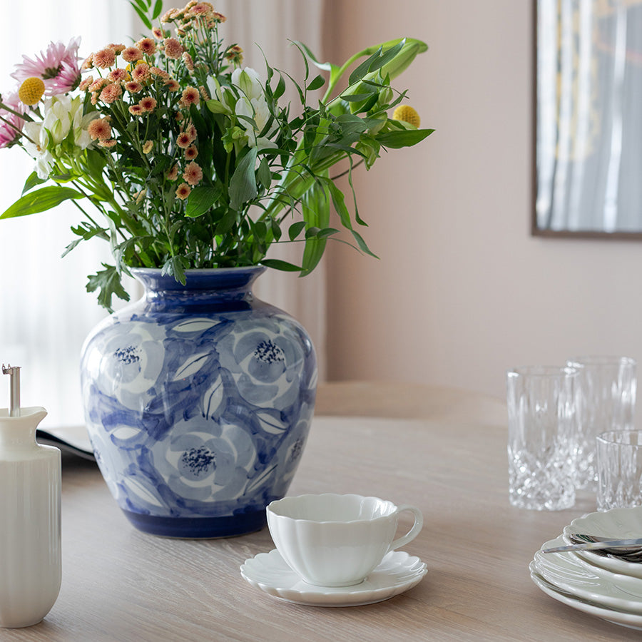 Vakker Nova Lilly Kopp Og Skål med blomsterdekor i en stilren setting. Perfekt for servering av kaffe eller te, designet av NOVA.
