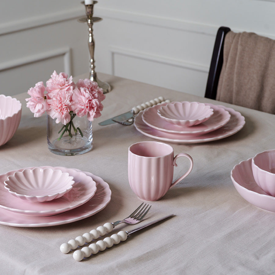 Elegant dekoret borddekorasjon med Lilly krus og matchende tallerkener i dus rosa, perfekt for feminine hjem.