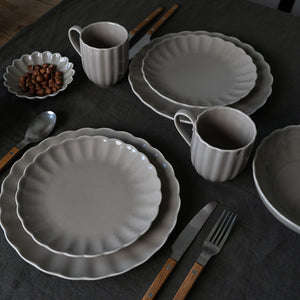 Kaffesett med grått Lilly krus og matchende tallerkener. Elegant borddekking med moderne kjøkkenutstyr.