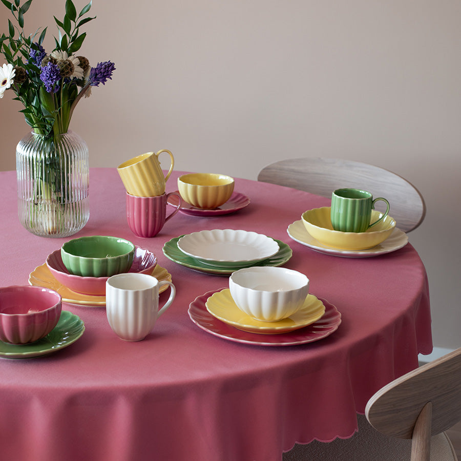 Variert fargerik borddekking med Nova Lilly Frokostservise, inkludert gul, rosa og grønn keramikk, ideelt for lunsj og frokost.