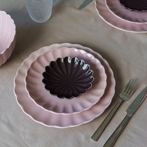 Borddekk med Nova Lilly skål i plommefarge, kombinert med rosa tallerkener, viser stilfull borddekking.