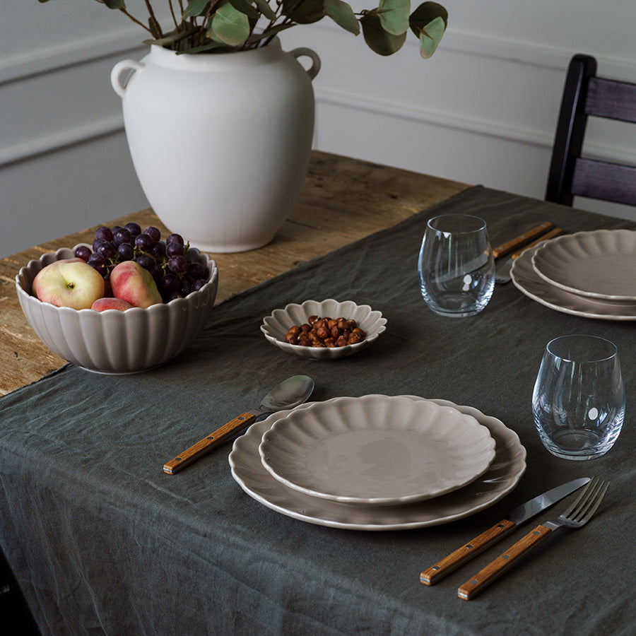 Stilig bordinnstilling med Nova Lilly tallerken, bolle og glass, fremhever tallerkenens delikate gråfarge.