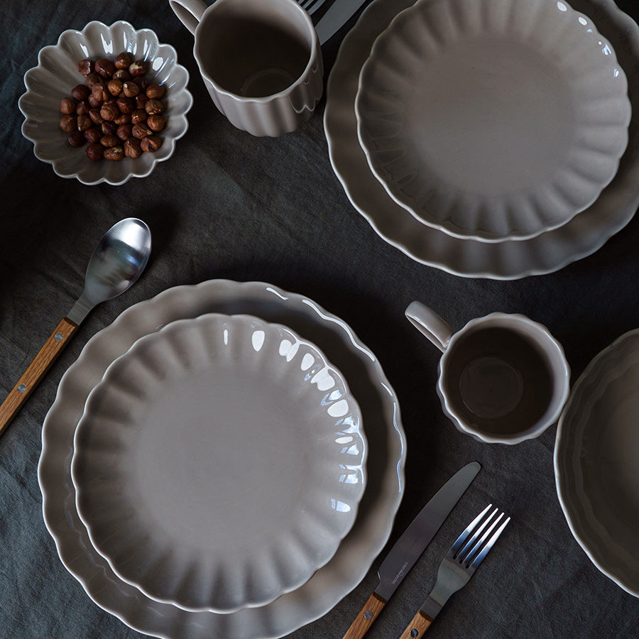 Borddekk med Nova Lilly tallerken i grå sammen med matchende krus og skåler, ideelt for elegant borddekor.