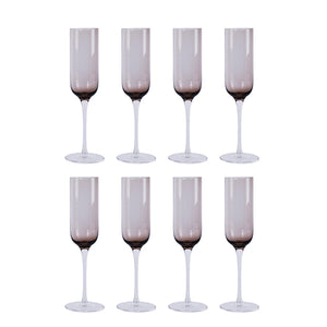 Sett med åtte sotet brune champagneglass fra Nova Nordic, designet for å fremheve bobler og eleganse under festligheter.