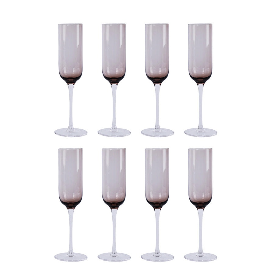 Sett med åtte sotet brune champagneglass fra Nova Nordic, designet for å fremheve bobler og eleganse under festligheter.