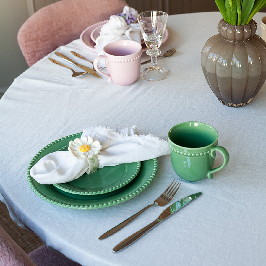 Et vakkert borddekken med grønne Nova Poppy krus, tallerkener og glass, perfekt for helgebrunch.