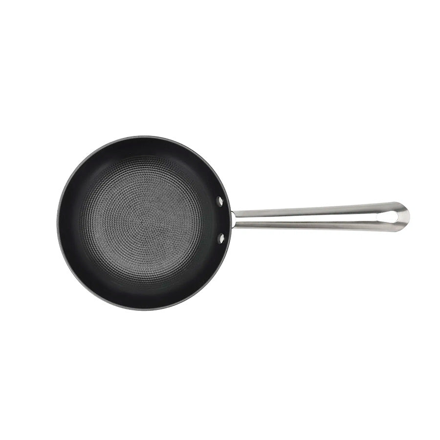 Oversiktsbilde av Pillivuyt Garonne 20 cm støpejernspanne med keramisk belegg, med bikubemønster i bunnen.