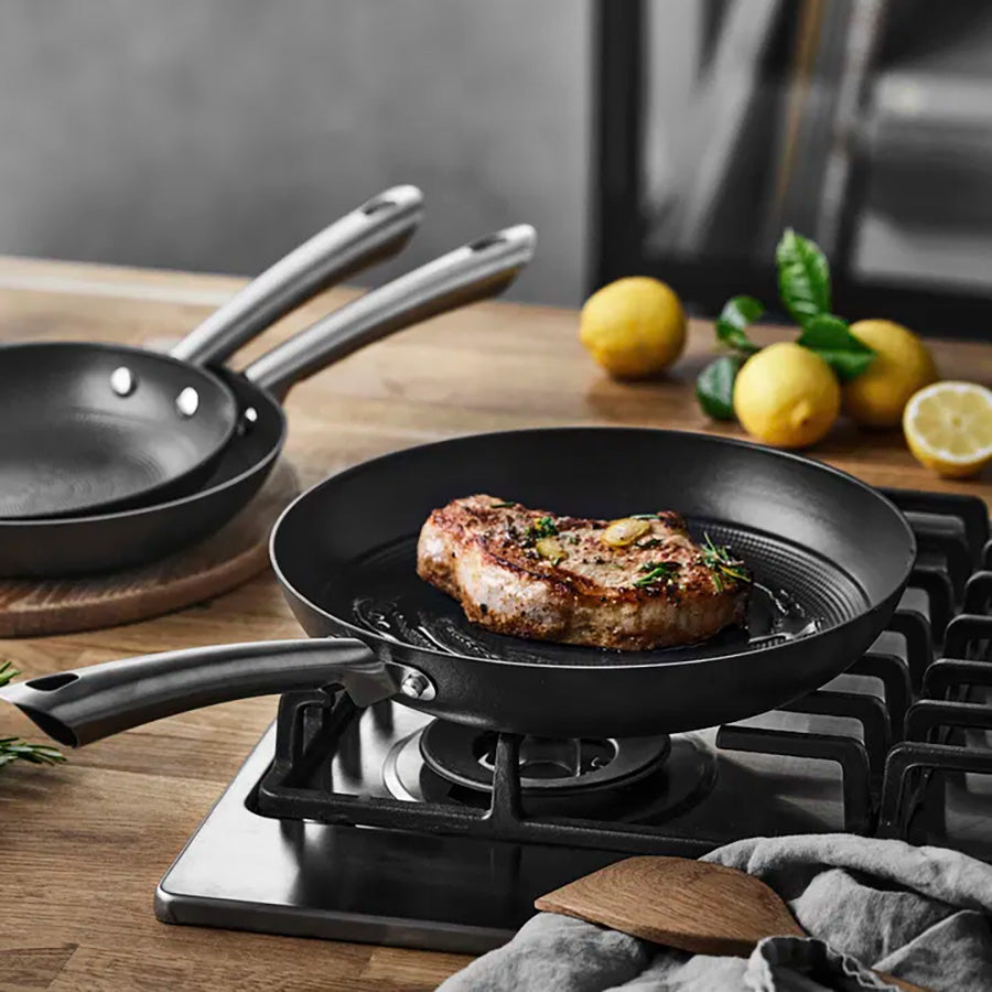 Stekepanne i bruk med saftig biff på komfyren, perfekt for grilling med støpejernspanne.