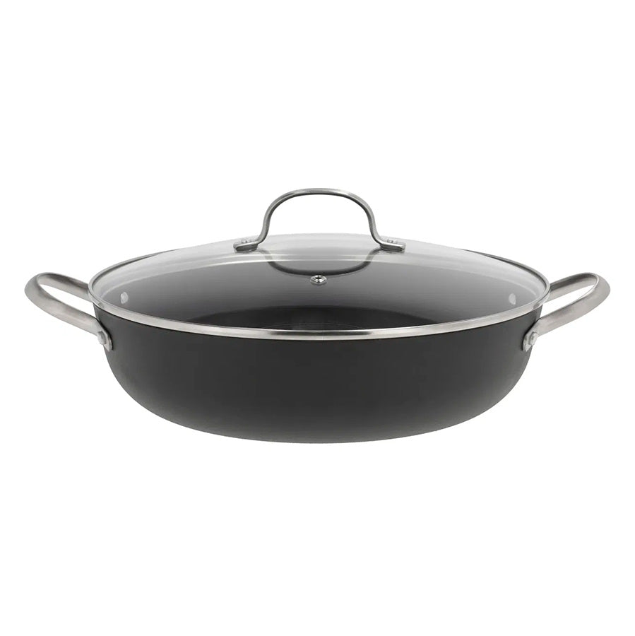 Støpejern wokpanne med glasslokk, perfekt for matlaging med jevn varmefordeling.