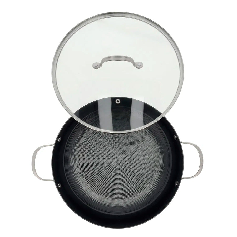 Oversikt av wokpanne med glasslokk og bikubemønster på bunnen for optimal steking.