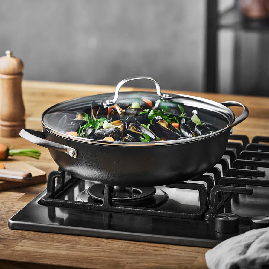 Wokpanne med muslinger og grønnsaker, demonstrerer allsidigheten i matlaging.