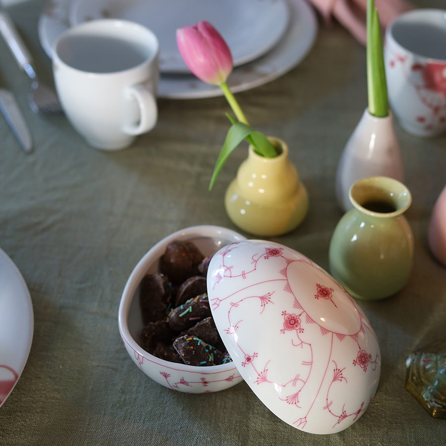 Porsgrunds porselænsfabrik påskeegg i rosa på et festdekket bord sammen med tulipaner og servise.