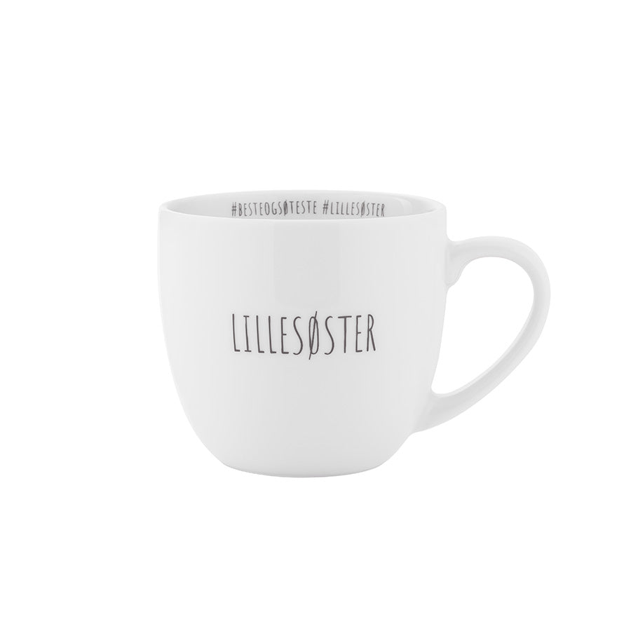 Lillesøster krus i hvit porselen med humoristisk hashtag-design og teksten 'Lillesøster' på siden.