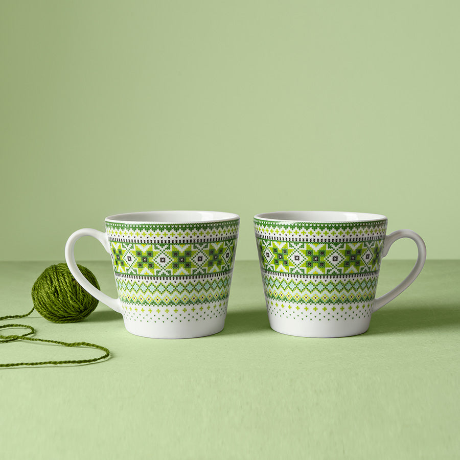 To Ingrid krus i grønt dekorert mønster, plassert på en myk overflate med grønn bakgrunn.