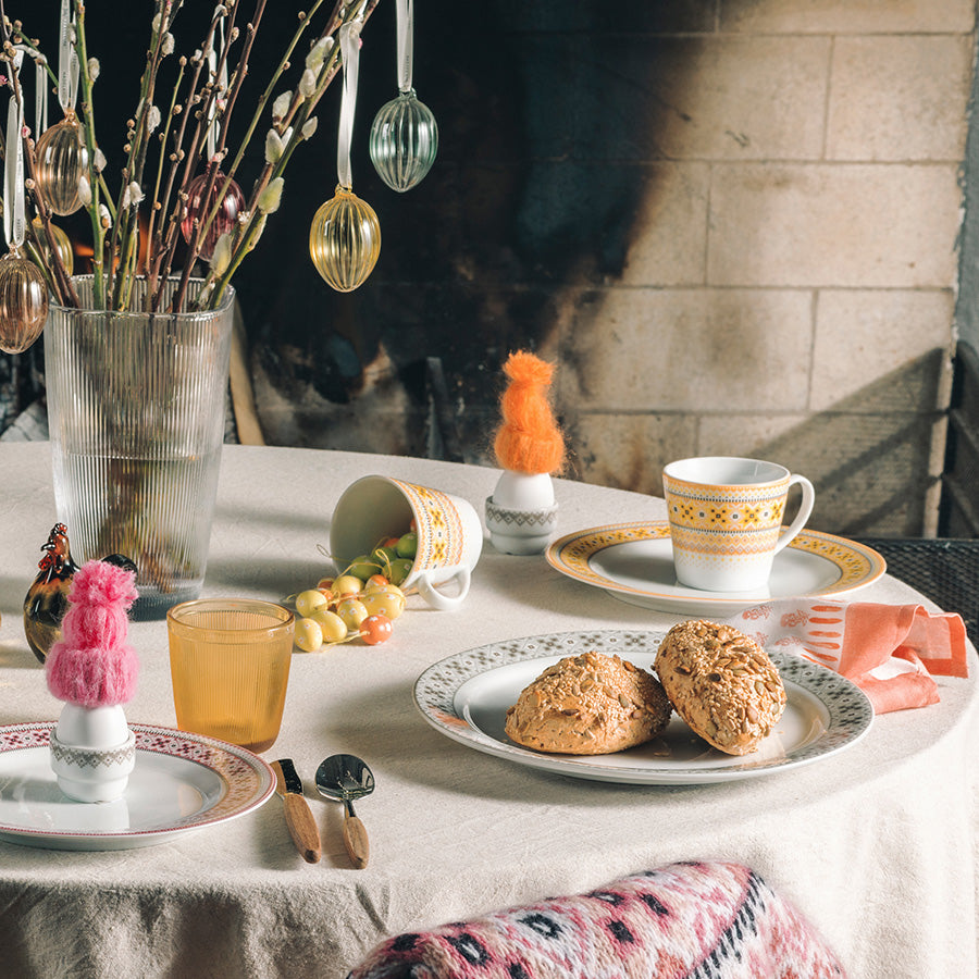 Porsgrunds Porselænsfabrik Ingrid Krus 40cl Gul på bord med andre serveringsfat, samlet for en koselig frokostopplevelse.