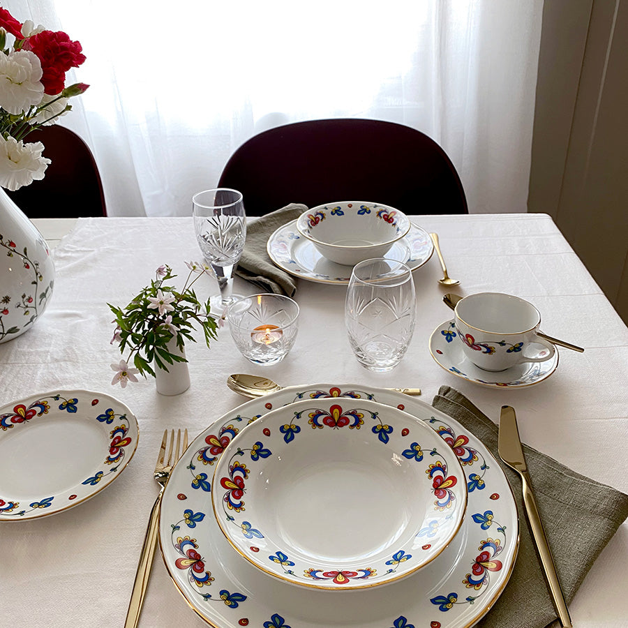 Bondemønster kopp og skål på elegant dekket middagsbord med matchende servise