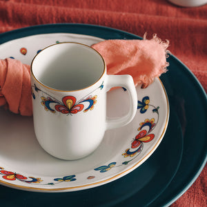 Porsgrund Bondemønster krus med kaffe plassert på matchende tallerken og mørkblå duk