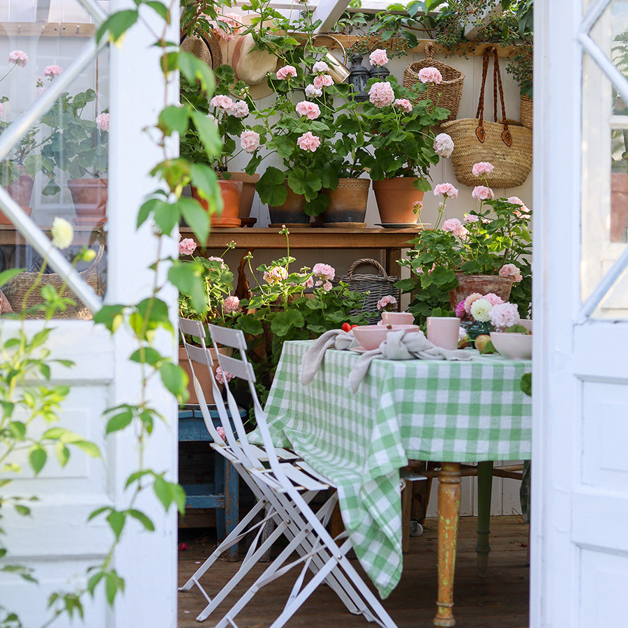 Koselig dekket bord med Porsgrunds Porselænsfabrik Ellie Krus m/Hank 33cl Rose blant blomster. Perfekt for en hyggelig frokost eller ettermiddagskaffe.
