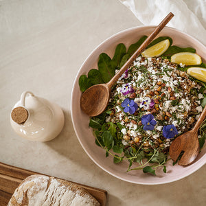 Serveringsbolle fra Porsgrunds Porselænsfabrik fylt med fersk salat, dekorert med blomster og sitronbiter.