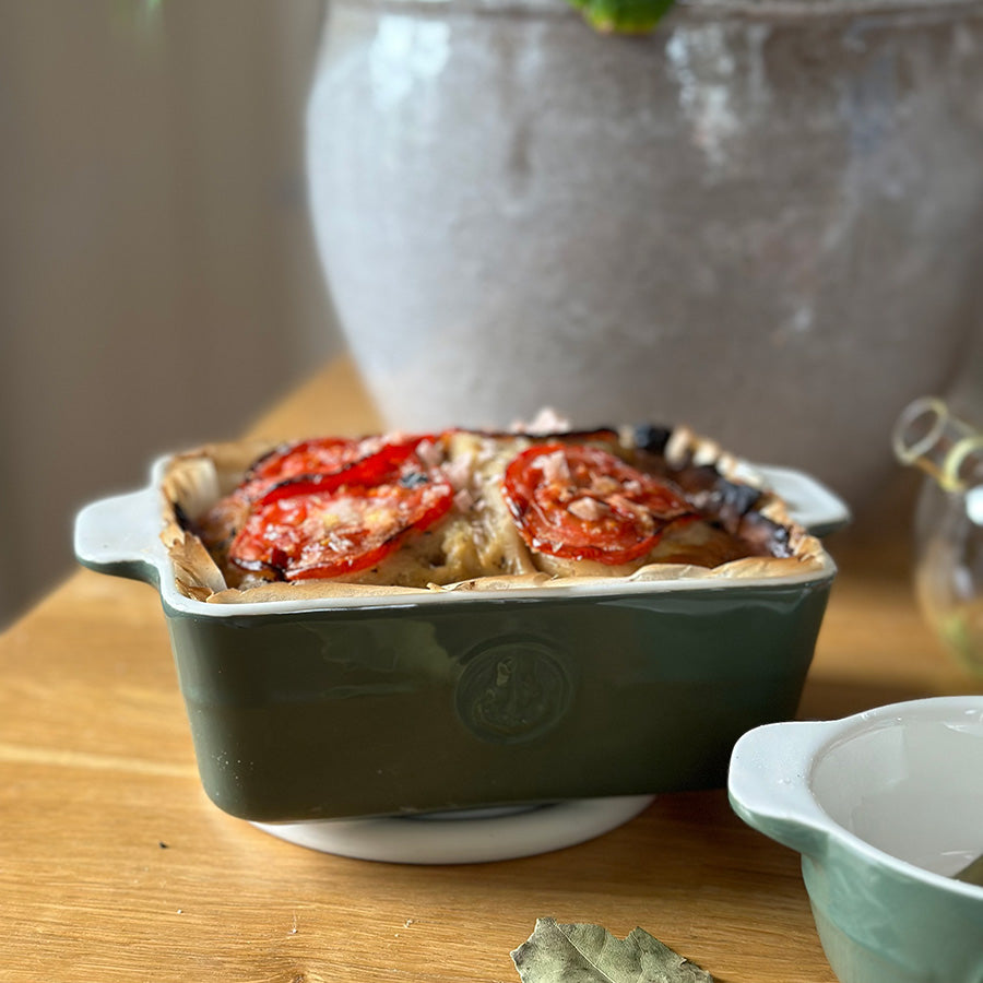 Grønn ildfast form fra Porsgrunds Porselænsfabrik med grateng og tomater, vist på kjøkkenbord