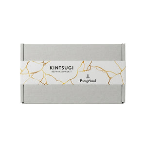 Porsgrunns Kintsugi kit med elegant eske, designet for reparasjon av keramikk med gullfargede linjer.