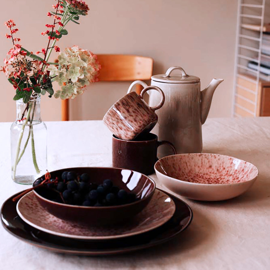 Elegant borddekorasjon med Porsgrunds tallerken, kopper og en tekanne, ideelt for lunsj med varm fargepalett.