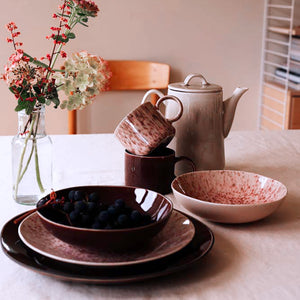 Elegant borddekorasjon med Porsgrunds tallerken, kopper og en tekanne, ideelt for lunsj med varm fargepalett.