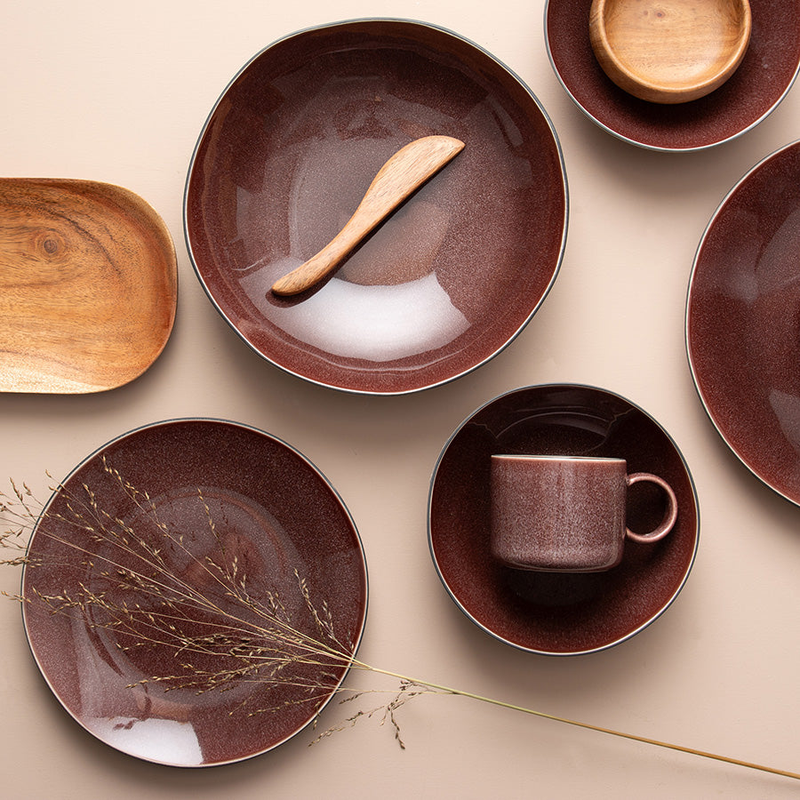 En samling av Porsgrunds Porselænsfabrik Natur krus og tallerkener i burgunder, perfekt for en vakker borddekking.