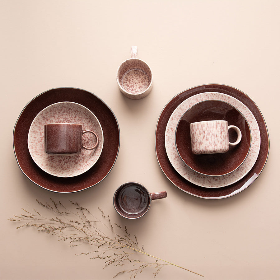 Middagstallerkener og krus fra Porsgrunds Porselænsfabrik Natur-serien, med burgunder og mønstrede detaljer, ideelt for servering.