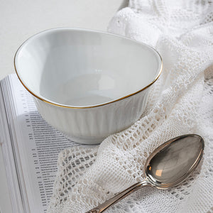 Tom Spire Gull musliskål med gullkant ved siden av en sølvskje og blondeduk