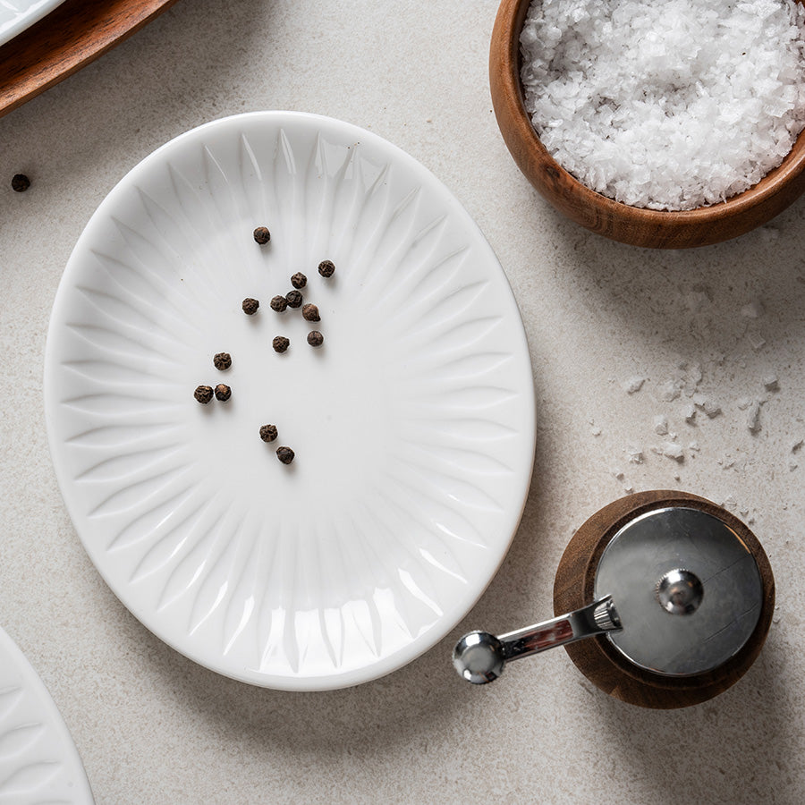 Spire oval asjett 16 cm med pepperkorn, ved siden av havsalt og pepperkvern