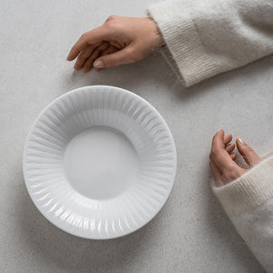 Tom Spire serveringsskål 22 cm på et lyst bord med hender ved siden av