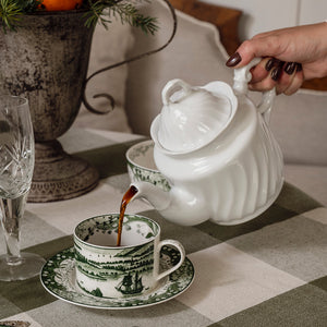 Grønn Vintage kopp med skål fylles med kaffe fra en hvit tekanne