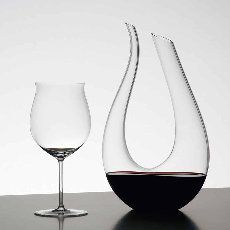 Riedel Karafler Dekanter Amadeo 1,5L sammen med et vinglass, illustrerer den elegante utformingen og funksjonaliteten til dekanteren.